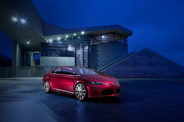 Carro vermelho brilhante no fundo da casa à noite