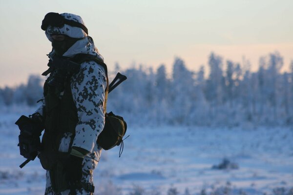 Homem em camuflagem no fundo da paisagem de Inverno