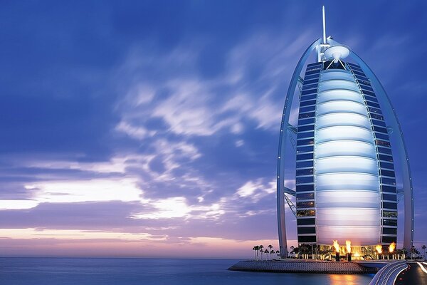 A torre da vela que sai com uma torre no céu ao pôr do sol