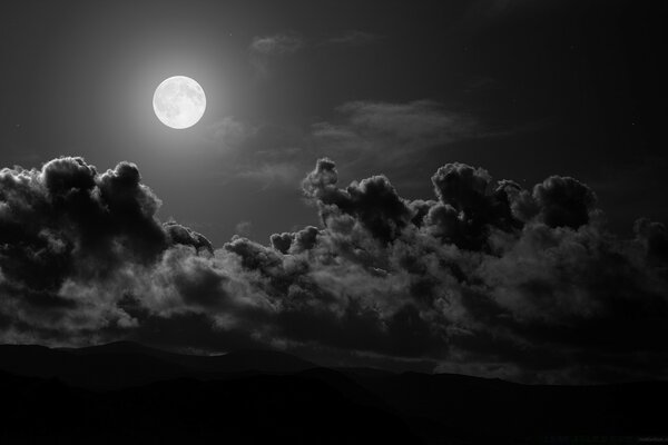 Imagem do céu com a Lua e grandes nuvens negras
