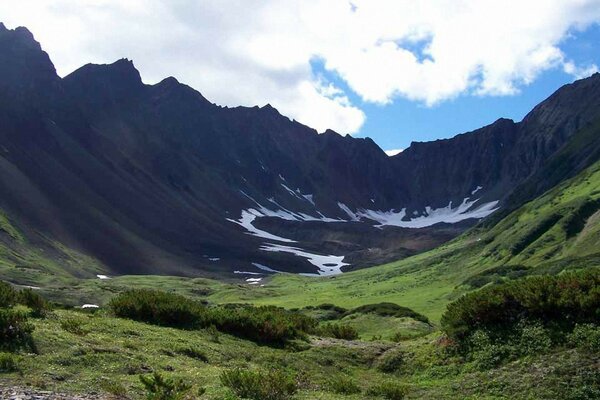 Belas montanhas e uma clareira verde