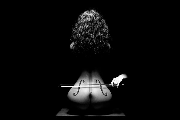 Foto em preto e branco de mulher nua estilizada em violoncelo