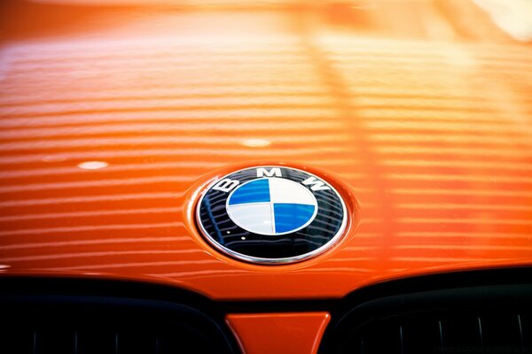 Emblemas do carro de BMW no fundo alaranjado