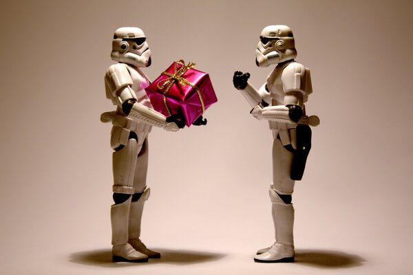 Figuras de robôs do filme Star wars com um presente em suas mãos