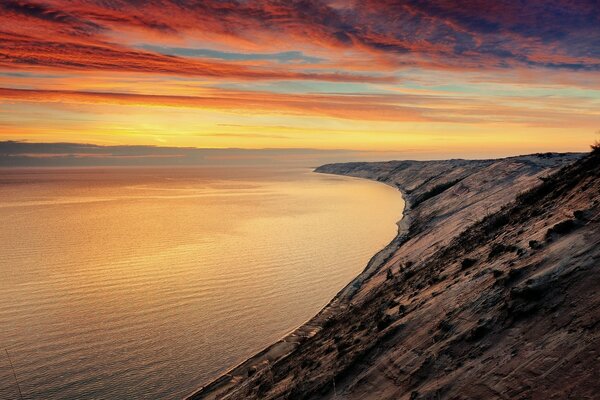 Praia rochosa perto da água ao pôr do sol