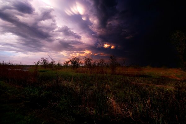 Pôr do sol mágico através das nuvens no campo