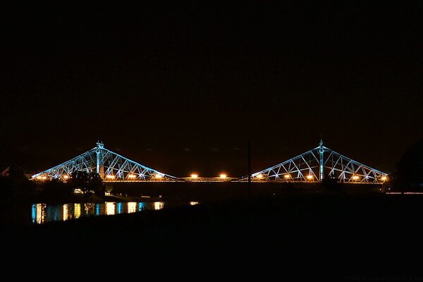 A luz da ponte na noite e seu brilho na água