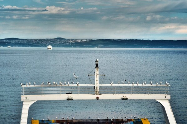 Foto do mar de um navio com montanhas ao fundo
